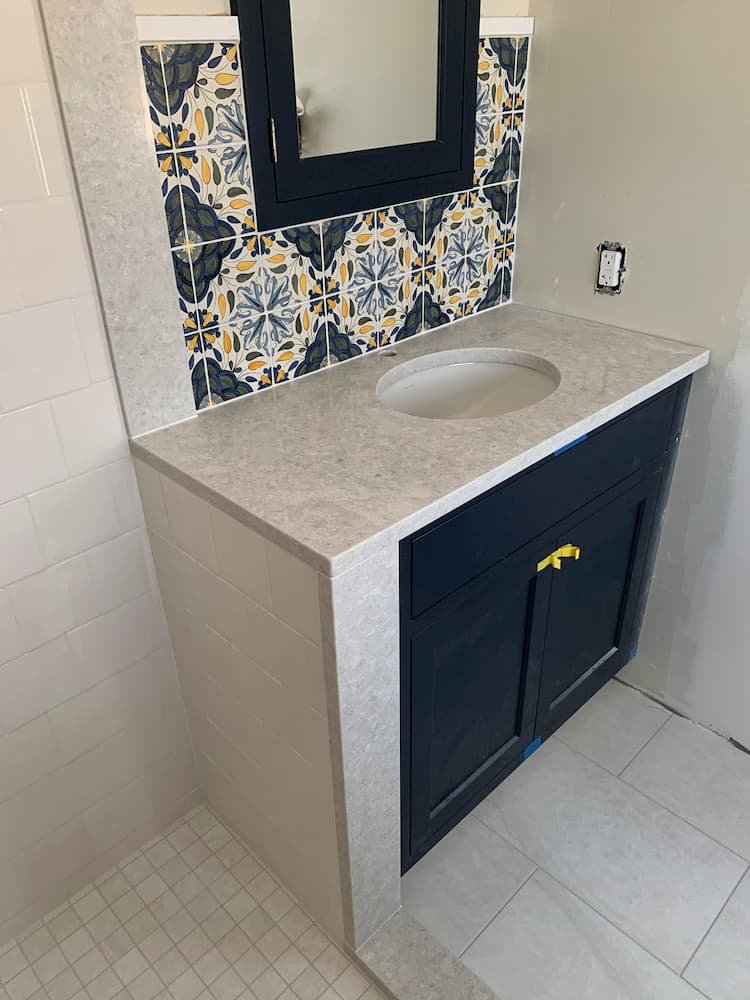 artistic tile finishing work above bathroom sink