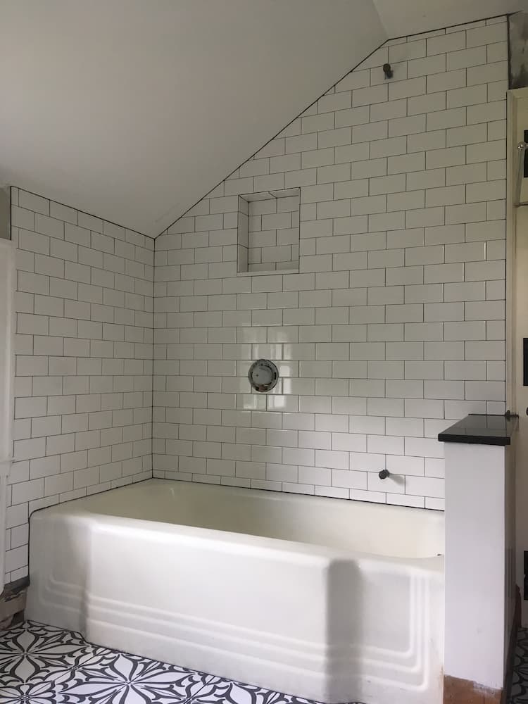 white subway tile shower with blue asymmetrical tile floor