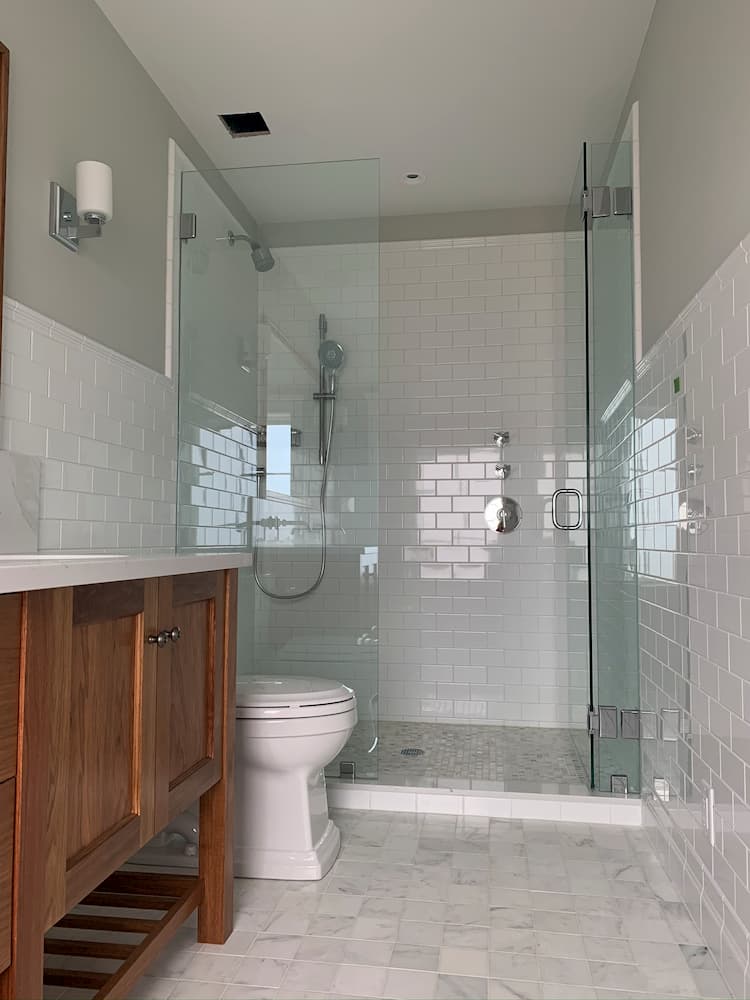 bathroom tile with brown cabinets and large mirror