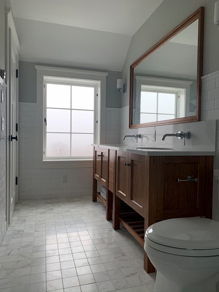 bathroom tile with brown cabinets and large mirror