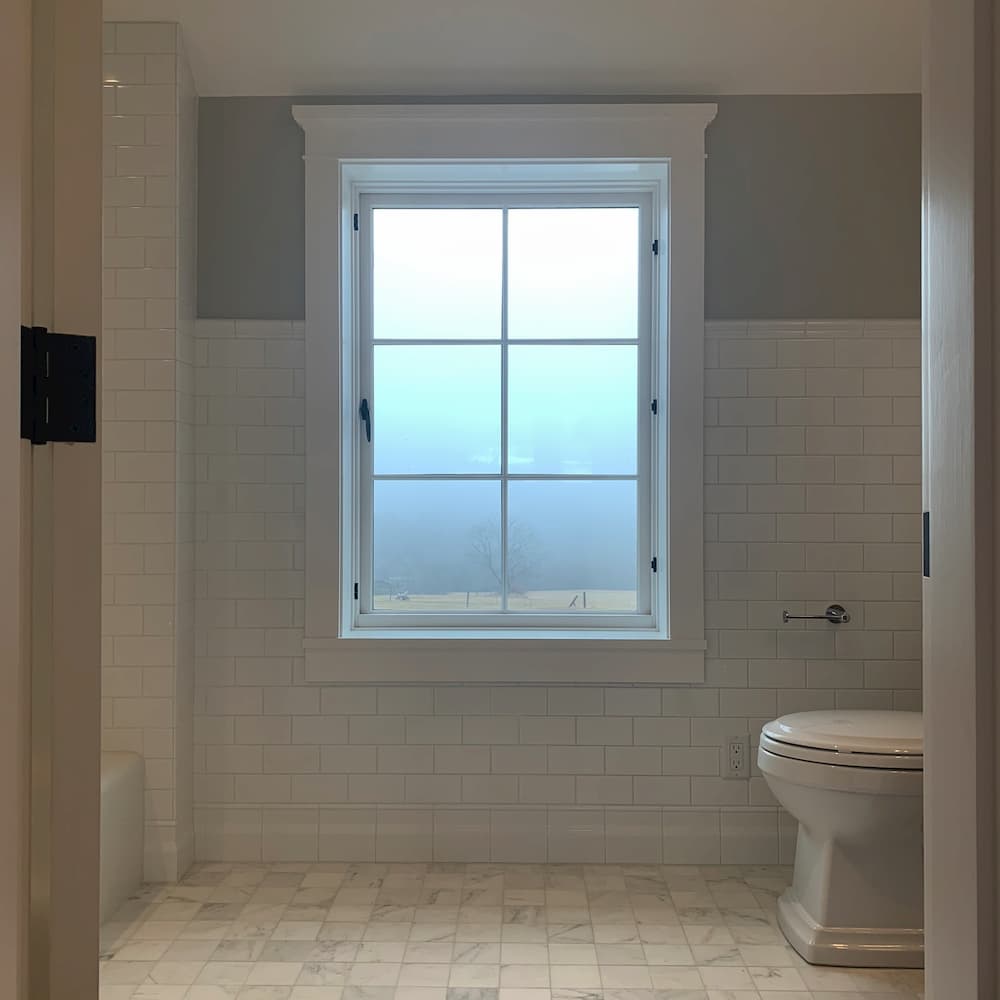 grey and white tile bathroom wall with window.